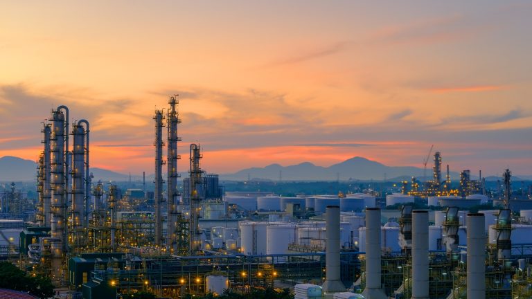 Oil refinery panoramic view at sunset with storage tanks