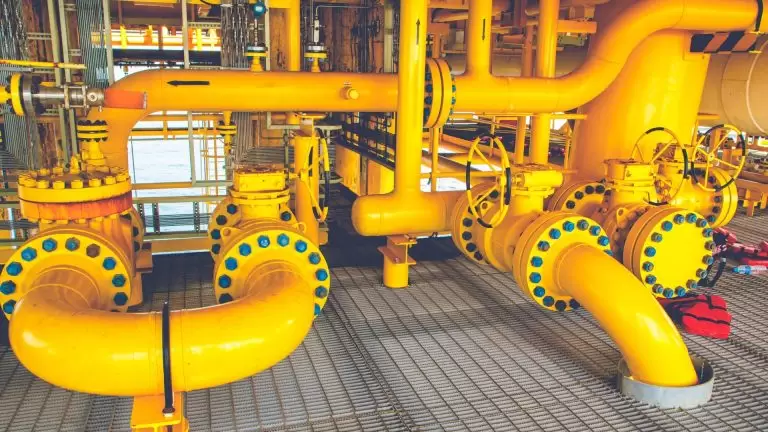 Yellow industrial pipes and valves at oil and gas processing facility
